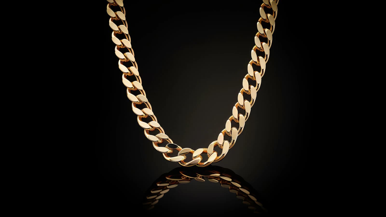 Gold chain with warm highlights on a black background (illustrative photo)